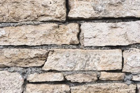 Close-up textured background is an irregular natural stone wall made of Stock Photos