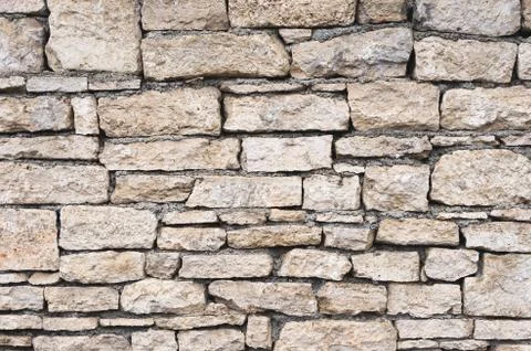 Close-up textured background is an irregular natural stone wall made of Stock Photos
