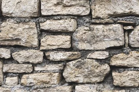 Close-up textured background is an irregular natural stone wall made of Foto stock