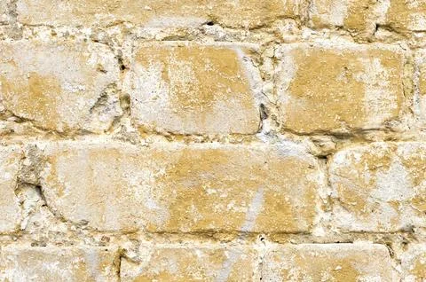 Close-up Textured background of a multi-colored brick painted in yellow. A 스톡 사진