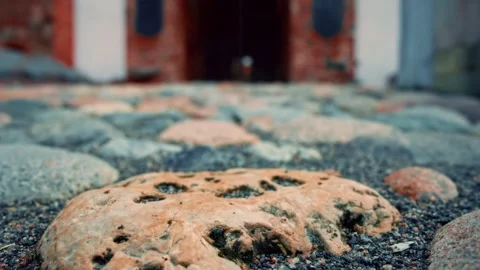 Close-up of textured cobblestone pathway leading to brick building Stock Footage 301124713