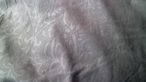Close-up of textured gray fabric with subtle floral pattern 스톡 사진