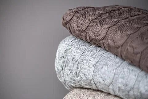 Close-up of textured knitted blankets in a stack. Stock Photos