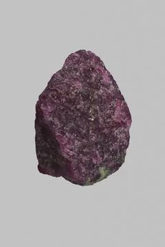 Close up textured purple Tanzanian ruby and zoisite stone on gray background Stock Photos