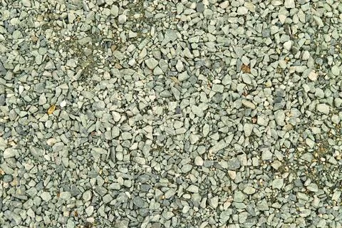 Close-up of a textured surface composed of small gray pebbles and rocks, cr.. Stock Photos