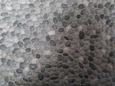 Close-up of a textured surface with small, rounded pebbles in various shade.. Stock Photos
