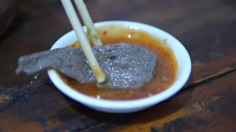 Close-up of Thai beef slice dipping in spicy sauce Stock Footage 320768856
