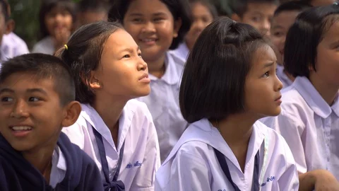 Close Up Of Thai Children in Primary School Uniforms Sitting Outside Stock Footage 129643703