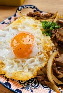 Close up Thai fried egg with stir fried minced pork, sliced onion on top Stock Photos