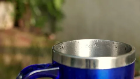 Close-up of a thermal coffee cup on the table. Hot steam rises from the coffee Stock Footage 343903350