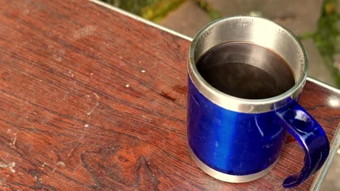 Close-up: thermal coffee cup on a table. Steam rises intensely from the espresso Stock Footage 345620232