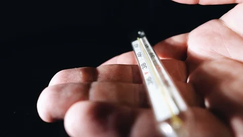 Close-up of a thermometer for the body of a man lying on the palm of his hand Stock Footage 127673292