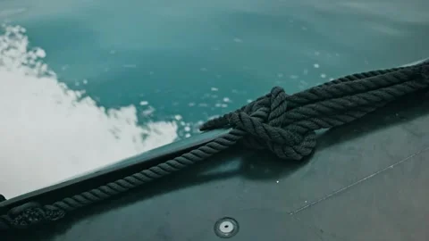 Close-Up of Thick Black Rope on Boat Deck with Churning Water Stock Footage 315094546