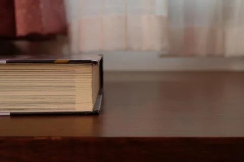 Close up of Thick old book that place on a table near to the window Stock Photos