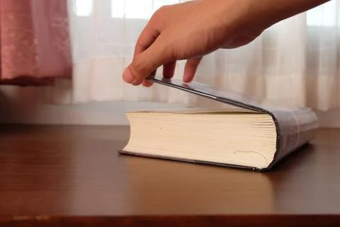 Close up of Thick old book that place on a table near to the window Stock Photos