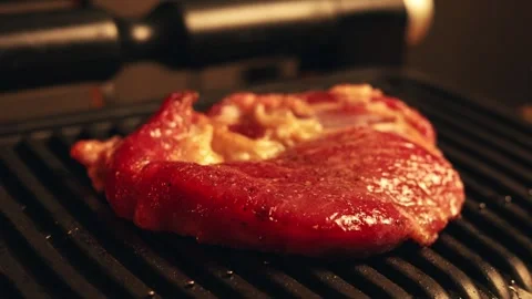 Close-up of thick steak sizzling on a hot grill with visible char marks Stock Footage 340562723
