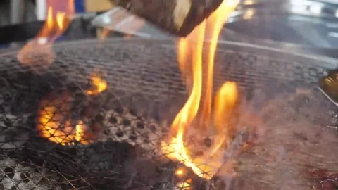 Close-up of Thick T-Bone Steak Grilling on Open Fire BBQ with Flames and Smoke Видео 338210957