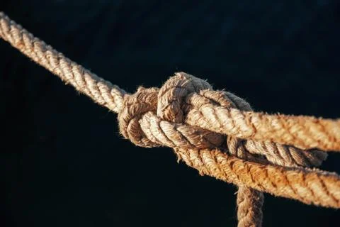 Close-up of a thick twisted hemp rope tied securely with a tight knot Stock Photos