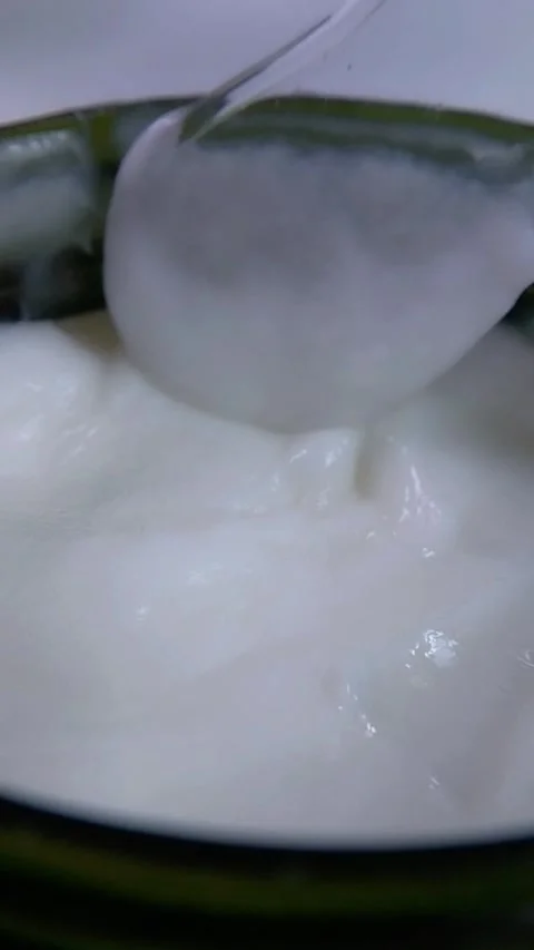 Close up of thick white cream in a container being stirred with a transpare.. Stock Footage 340329397
