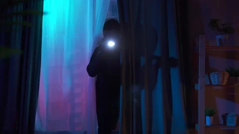 Close up thief in a balaclava climbs through the window of an apartment Stock Footage 155143425