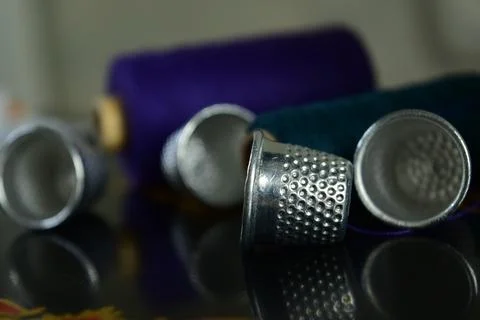 Close-up of thimbles and colored spools of thread Stock Photos