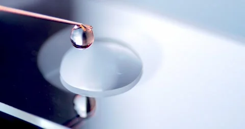 Close up of Thin Metal Needle Dispensing Medical Liquid onto Glass Slide in Slow Video stock 330956343