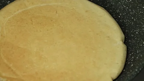 Close-up of thin pancake in a frying pan while cooking Stock Footage 201145456