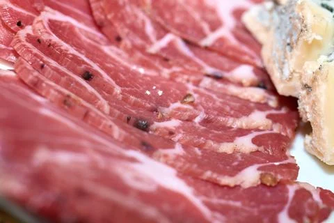 Close-up of thin slices of cured meat served as appetizer with blue cheese Stock Photos