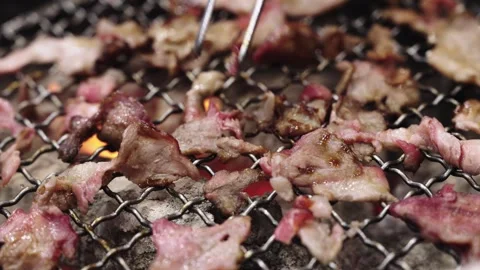 Close-up of thin slices of marbled beef grilling on a traditional charcoal .. Stock Footage 335359352