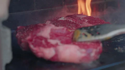 Close-up think steaks cooking on outdoor BBQ. Flames and hot coals sizzling Stock Footage 345806285