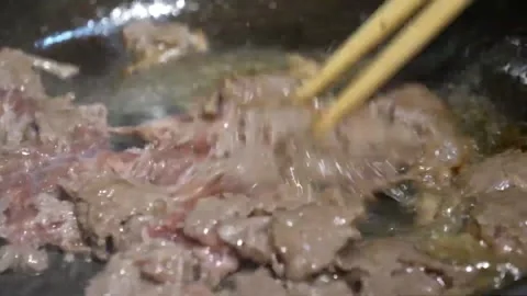 Close-up of Thinly Sliced Beef Sizzling in Hot Pan with Steam Stock Footage 337677974