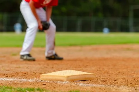 Close up of the third baseball base and a foul line with grass outfield in .. Stock Photos