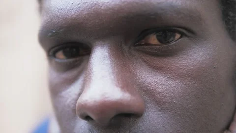 Close up of thoughtful black man sitting in urban street Stock Footage 217790508