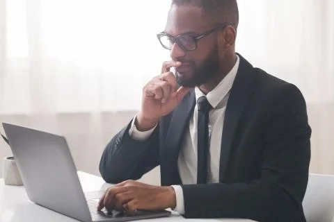 Close up of thoughtful manager reading emails on laptop Foto stock