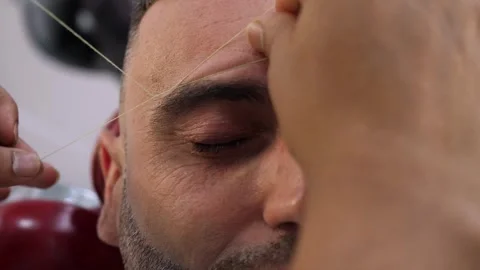 Close up threading eyebrows on young man detailed barber work 库存影片 333195825