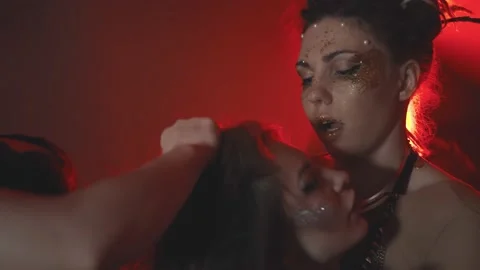 Close up of three beautiful models with stylish hair and makeup hugging on red Stock Footage 143976691