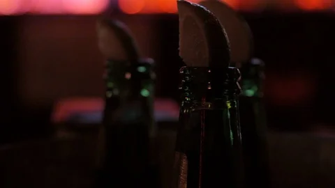 Close up of three beers with limes in dark bar 库存影片 97550091