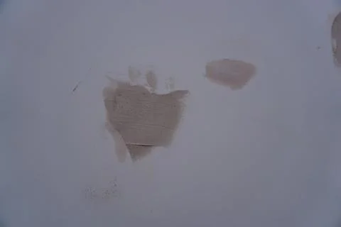 Close-up of three beige rough textured streaks and patches on an even light Stock-Fotos