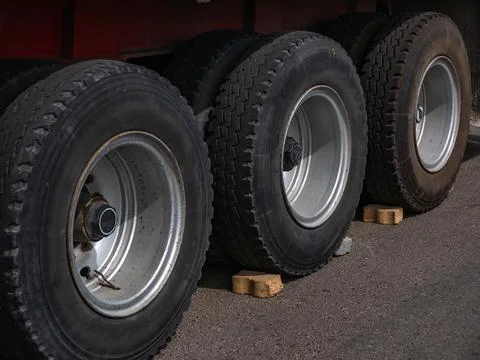 Close-up of three big black wheels on a truck trailer. Stock Photos