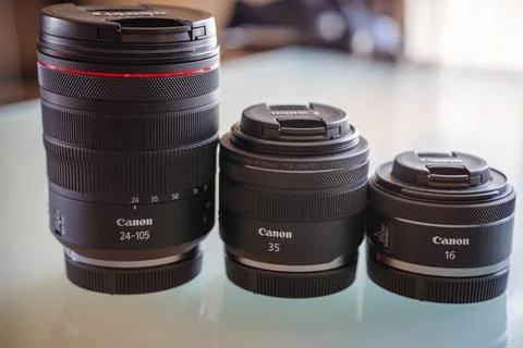 Close-up of three Canon RF camera lenses standing on a glass table Foto stock
