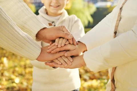 Close up of three Caucasian person stack their palms. Father, mother and son  Stock Photos