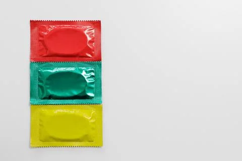 Close up of three colorful packages condoms with copyspace on white Stock Photos