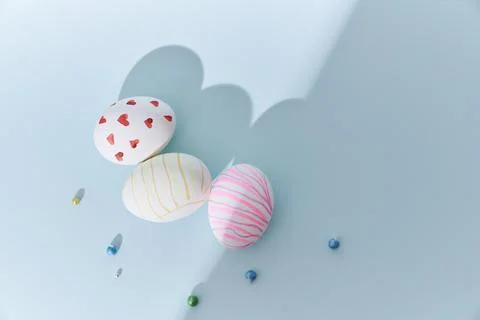 Close-up of three Easter eggs with a pattern of hearts and lines on a blue Stock Photos