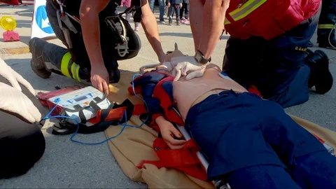 Close up of three fire brigade team practicing cpr on training dummy as Stock Footage 96676346