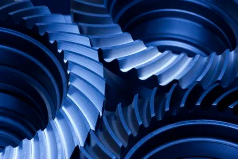 Close-up of three gear wheels in an engine in dark blue Stock Photos
