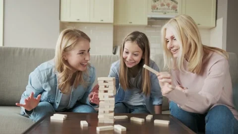 Close up three generations of women playing stack and crash board game together Stock Footage 152453350