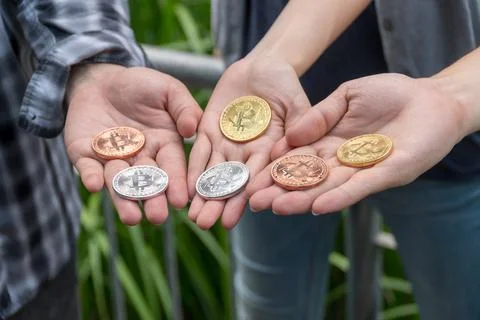 Close up three hand of Young men holding up golden, silver, copper bitcoin. F Foto stock
