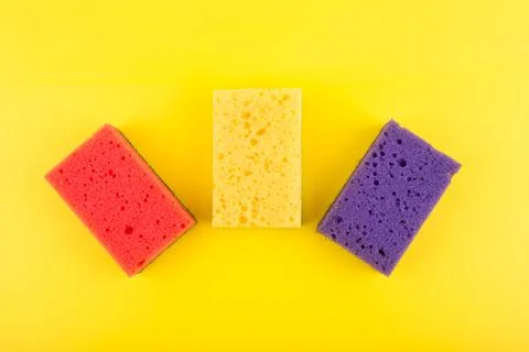 Close up of three multicolored red, purple and yellow cleaning sponges on bright Stock Illustration