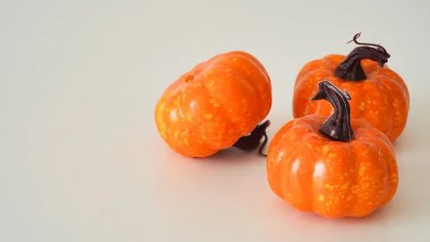 Close-up of three plastic orange pumpkins on a white background, copy space. 写真素材
