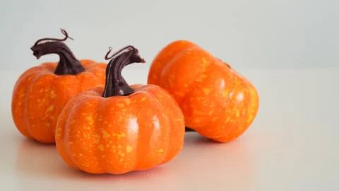 Close-up of three plastic orange pumpkins on a white background, copy space. 스톡 사진